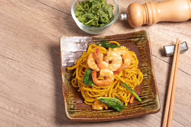 Fried noodles with shrimp in a plate on the table - Foto, Imagen