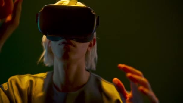 Молодой человек играет в виртуальный мир крупным планом. Сосредоточенный геймер носит голографические очки дополненной реальности, наслаждаясь неоновым светом. Цифровое пространство Гая. Концепция современной технологии Metaverse 3d - Кадры, видео