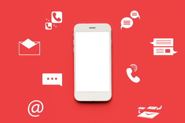 Mobile phone with blank screen and icons on red background - Photo, Image