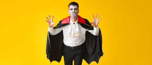 Man dressed as vampire for Halloween on yellow background - Foto, Imagem