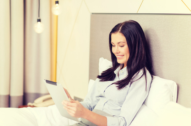 happy businesswoman with tablet pc in hotel room - Foto, afbeelding