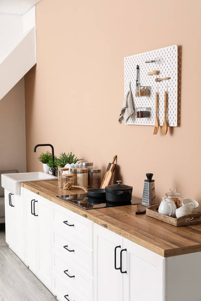 Інтер'єр стильної кухні з білими прилавками, посудом і дошкою
 - Фото, зображення