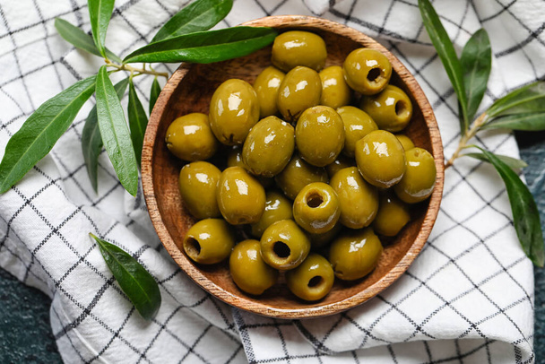 Bowl of delicious green olives on fabric background, closeup - Valokuva, kuva