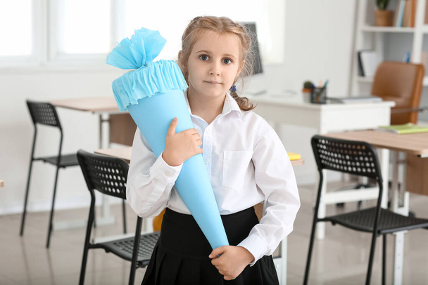 Cute little girl with blue school cone in classroom - Fotografie, Obrázek