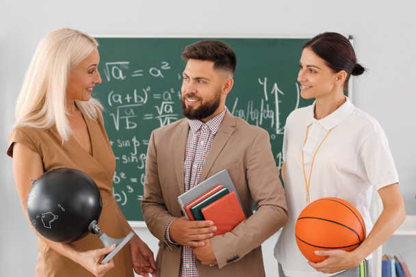 Teachers with globe, books and ball in classroom - Foto, Imagem