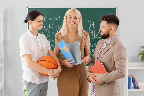 Teachers with books, world map and ball in classroom - Foto, Imagem