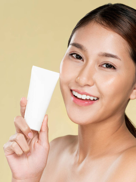 Closeup ardent woman smiling holding mockup product for advertising text place, light grey background. Concept of healthcare for skin, beauty care product for advertising. - Foto, afbeelding