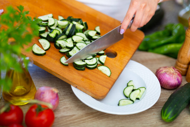 Image of female hands cut fresh cucumbers for vegetable salad, nobody - Valokuva, kuva