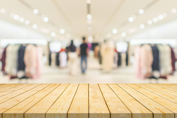 Пустой столешница из дерева с размытым бутиком одежды дисплей интерьера торгового центра фоне - Фото, изображение
