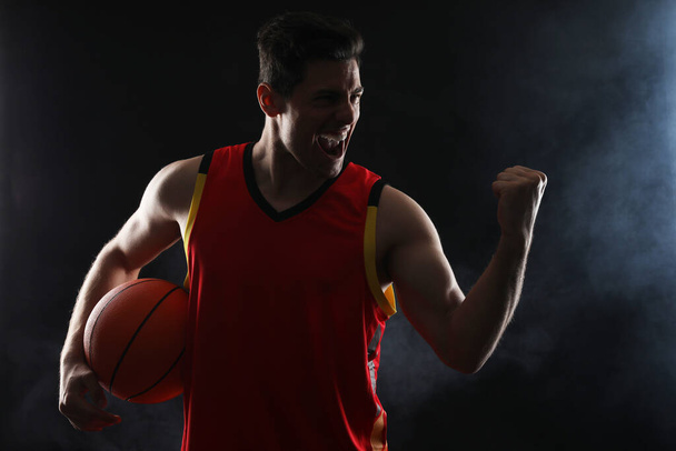 Basketball joueur avec balle sur fond noir - Photo, image