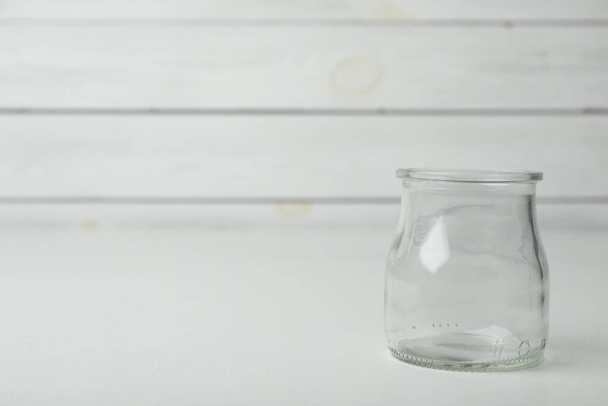 Empty glass jar on white table, space for text - Fotó, kép