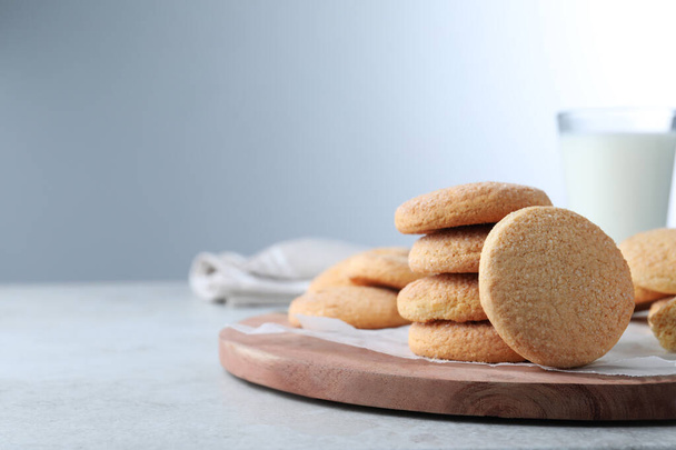 Many tasty sugar cookies on light grey table, space for text - Foto, afbeelding