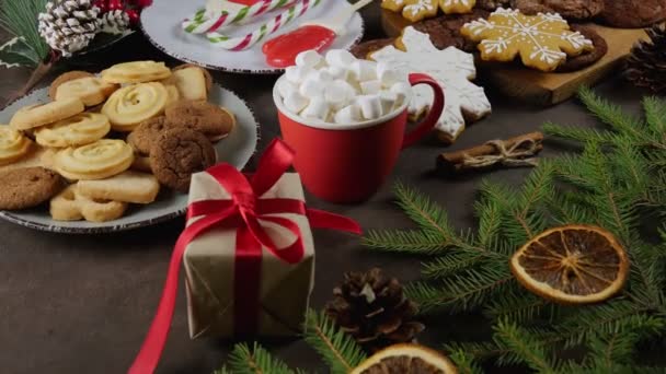 A cup of hot chocolate with marshmallows. Gingerbread cookies on a wooden table. Christmas. Family and holidays concept - Záběry, video