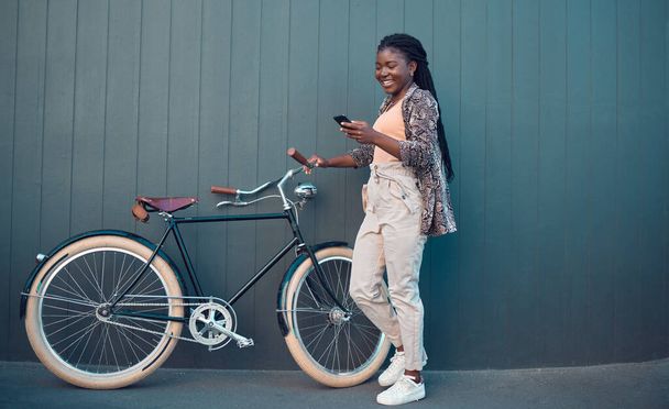 Girl, relax with bicycle and using smartphone app, social media and doing a internet or web search. Student uses her bike for health, fun workout or travel by cycling to school, university or college. - Φωτογραφία, εικόνα