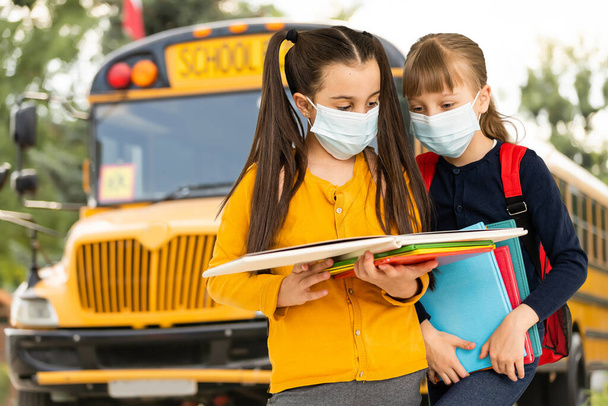 Children wearing face protective mask going back to school during corona virus pandemic. Healthcare and education concept. - Foto, immagini