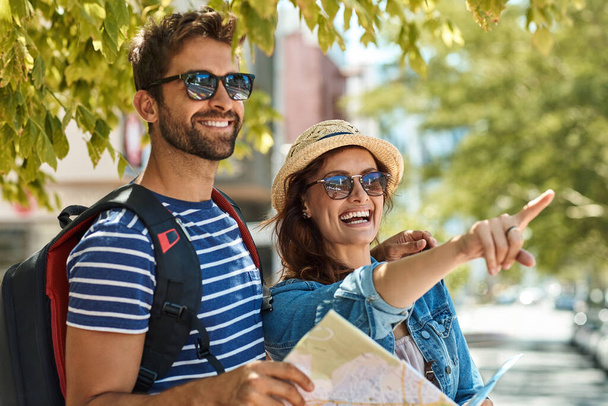 So many new things to see. a happy tourist couple using a map to explore a foreign city together - Foto, Imagem