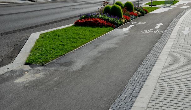 promenade for pedestrians and cyclists with a dividing island between the lanes and road, road markings sprayed with paint on asphalt. wheel, arrow and triangle traffic sign pictogram. luxury spa - 写真・画像