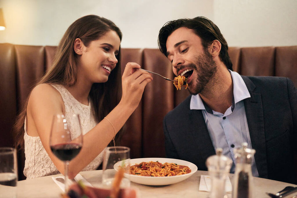 She definitely wifey material. a woman feeding her boyfriend while on a romantic date - Zdjęcie, obraz