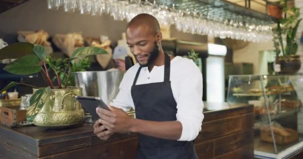Coffee shop owner, manager or waiter checking tablet for online orders, social media marketing or mobile app for management of inventory. Portrait of barista using technology for SME business tools. - Video