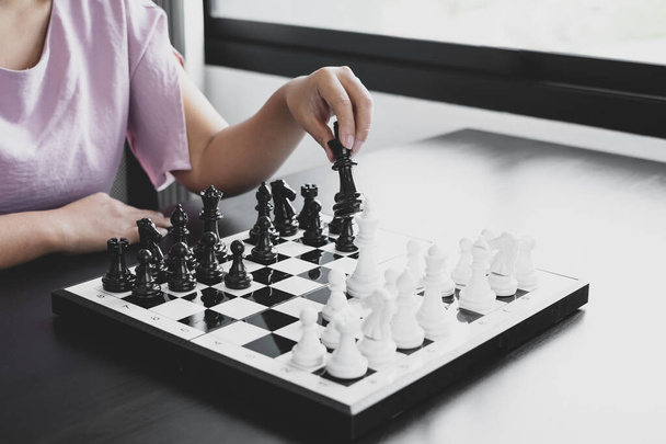 Hand van zakenvrouw bewegen, schaken in concurrentie toont leiderschap, volgers, en business succes strategieën. - Foto, afbeelding