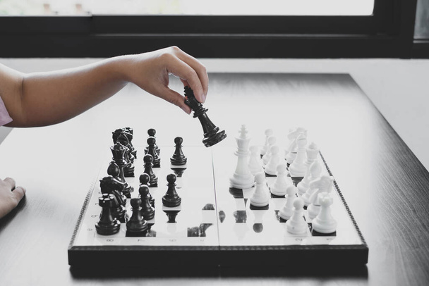 Mano de empresaria en movimiento, ajedrez en competición muestra liderazgo, seguidores y estrategias de éxito empresarial. - Foto, Imagen