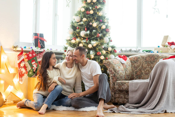 Christmas. Family. Happiness. Top view of dad, mom and daughter on the floor at home - Foto, Imagem