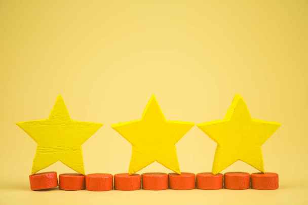 Три дерев'яні жовті зірки рейтинг форми для відгуків користувачів. Три жовті зірки рейтингу. Задоволення клієнтів оцінюється найвище для видатних послуг компанії. Концепція опитування задоволення
. - Фото, зображення