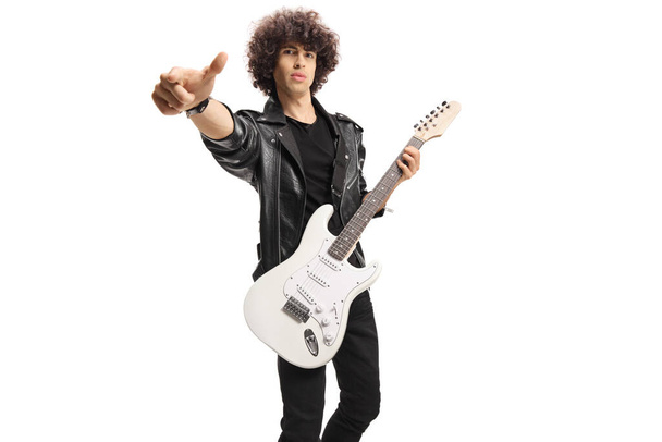 Rock musician in a black leather jacket with an electric guitar gesturing with fingers isolated on white background - Foto, afbeelding