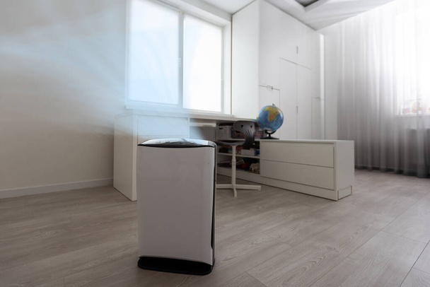 Air purifier in cozy white living room for filter and cleaning removing dust PM2.5 HEPA and virus in home, for fresh air and healthy Wellness life, Air Pollution Concept. - 写真・画像