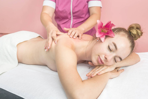 Young beautiful woman getting relaxing back and body massage in beauty salon - Photo, Image