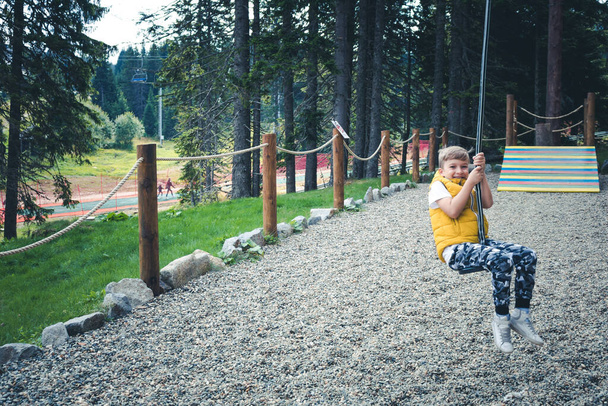 Happy boy on zip line having fun in the park. - Fotoğraf, Görsel