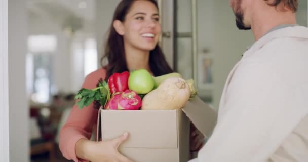 Delivery man with box or grocery for online shopping order to woman customer at the house door. Happy smile after receiving food stock package from logistics supply chain worker or employee at home. - Footage, Video