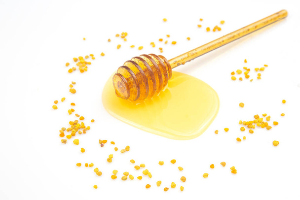 spoon with fresh honey and pollen spilled on a white background. organic vitamin food - Zdjęcie, obraz