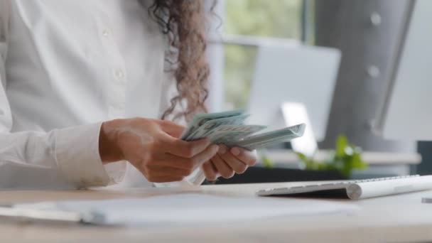 Unrecognizable young woman accountant counts cash at workplace female office worker bank cashier calculates salary with paper dollar bills monthly calculation finance budget savings currency exchange - Felvétel, videó