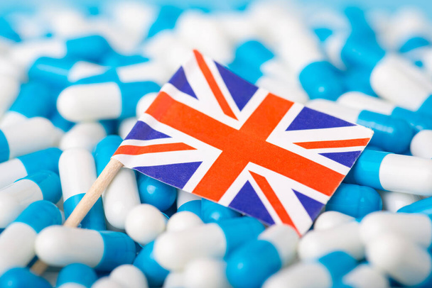 Pandemic in UK. Union Jack on pile of medical pills capsules - Fotografie, Obrázek