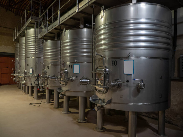 Fermentation in progress. Tankers for fermenting wine inside a wine factory in Catalonia, Spain. - Foto, afbeelding