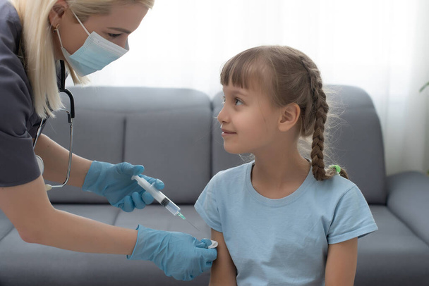 Little girl getting vaccination from pediatrician at medical office. - Фото, зображення