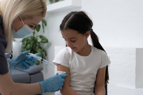 Ragazzina ottenere la vaccinazione dal pediatra presso lo studio medico. - Foto, immagini