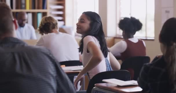 Learning, education and teen student in a high school classroom with students in a exam. Portrait of a happy girl with a smile in class looking back from learning, studying and working at a desk. - Video