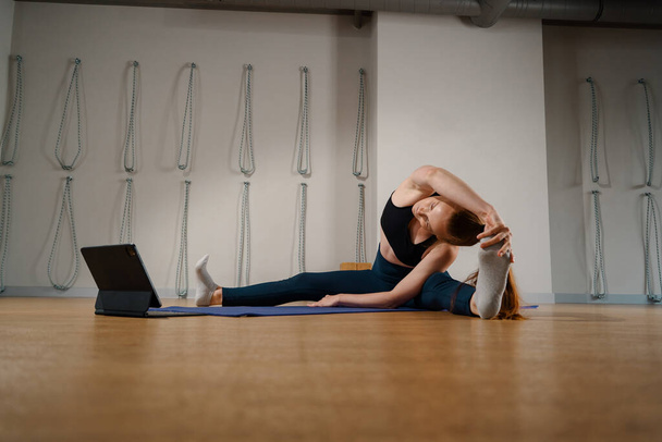 Athletic woman doing yoga pilates stretching online workout in studio or at home - Foto, immagini