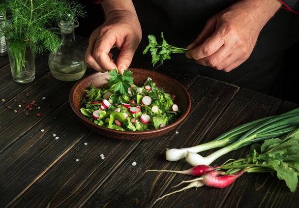 The chef prepares a delicious fresh vegetable salad for lunch. Vegetarian cuisine - 写真・画像
