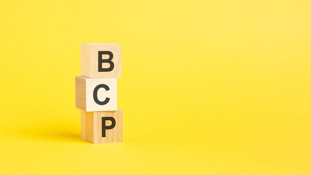 Текст BCP на дерев'яному блоці з жовтим фоном - Фото, зображення