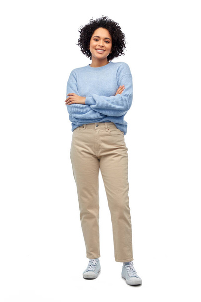 people, fashion and style concept - happy smiling woman in blue sweater and jeans over white background - Photo, Image