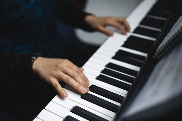 Close up of womans hands playing piano by reading sheet music. High quality photo - Fotó, kép
