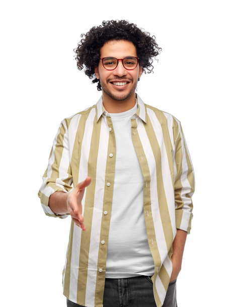 people and fashion concept - happy smiling man in glasses giving hand for handshake over white background - Photo, Image