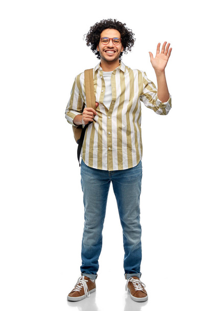 travel, fashion and education concept - happy smiling man in glasses with backpack waving hand over white background - Φωτογραφία, εικόνα