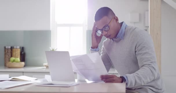 Tax, debt or compliance and a business man remote working at home with stress, anxiety and burnout. Laptop, document and paper work with a startup worker reading, typing and thinking in the kitchen. - Filmmaterial, Video