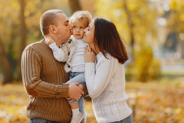 Family with cute little daughter. Father in a brown sweater. Family in a autumn field - Фото, зображення