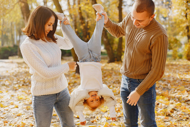 Family with cute little daughter. Father in a brown sweater. Family in a autumn field - Foto, afbeelding