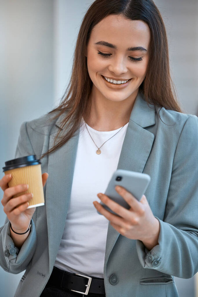 Happy business woman on social media with phone and smile with cup of coffee in the office. Company employee reading a funny meme, text or comedy video on the internet and work email online on mobile. - Photo, image